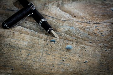 black and silver fountain pen on brown wooden table